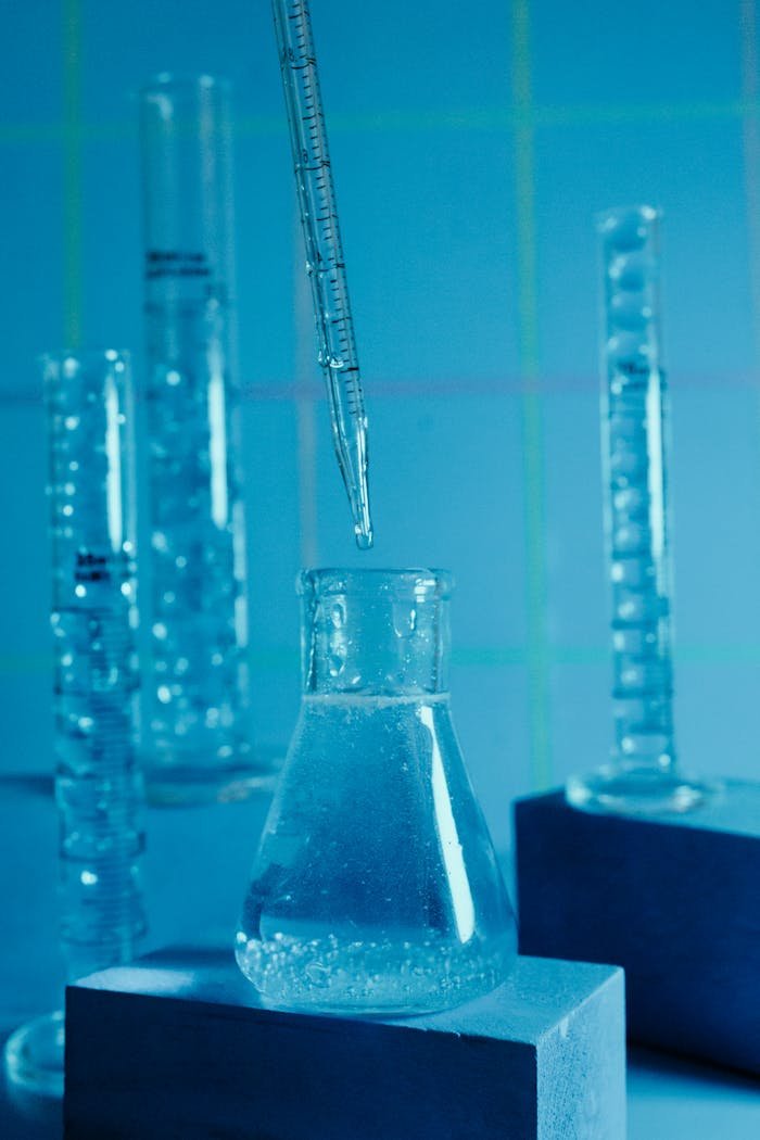 about-us Close-up of laboratory beakers with a pipette, highlighting scientific research.